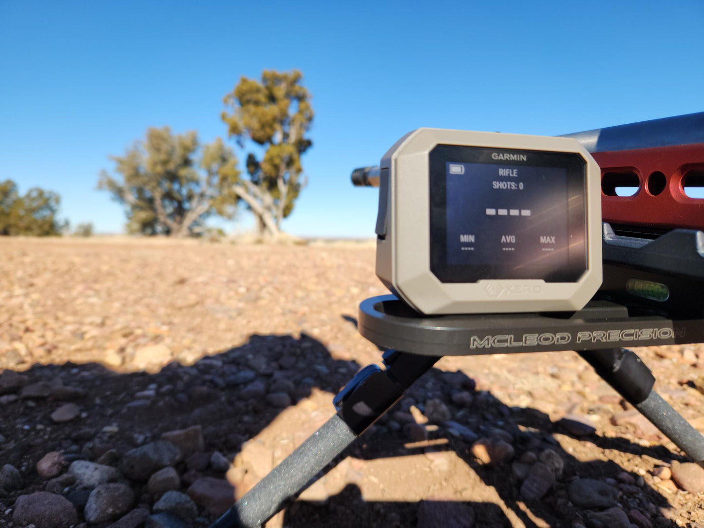 Picture of a Garmin Xero installed on the Xero Sled in black finish on a red rifle