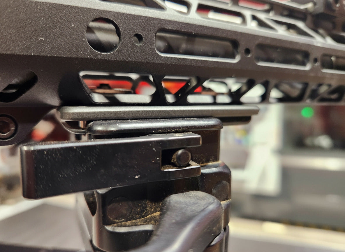 Mini Arca rail mounted to rifle and clamped into a tripod picture