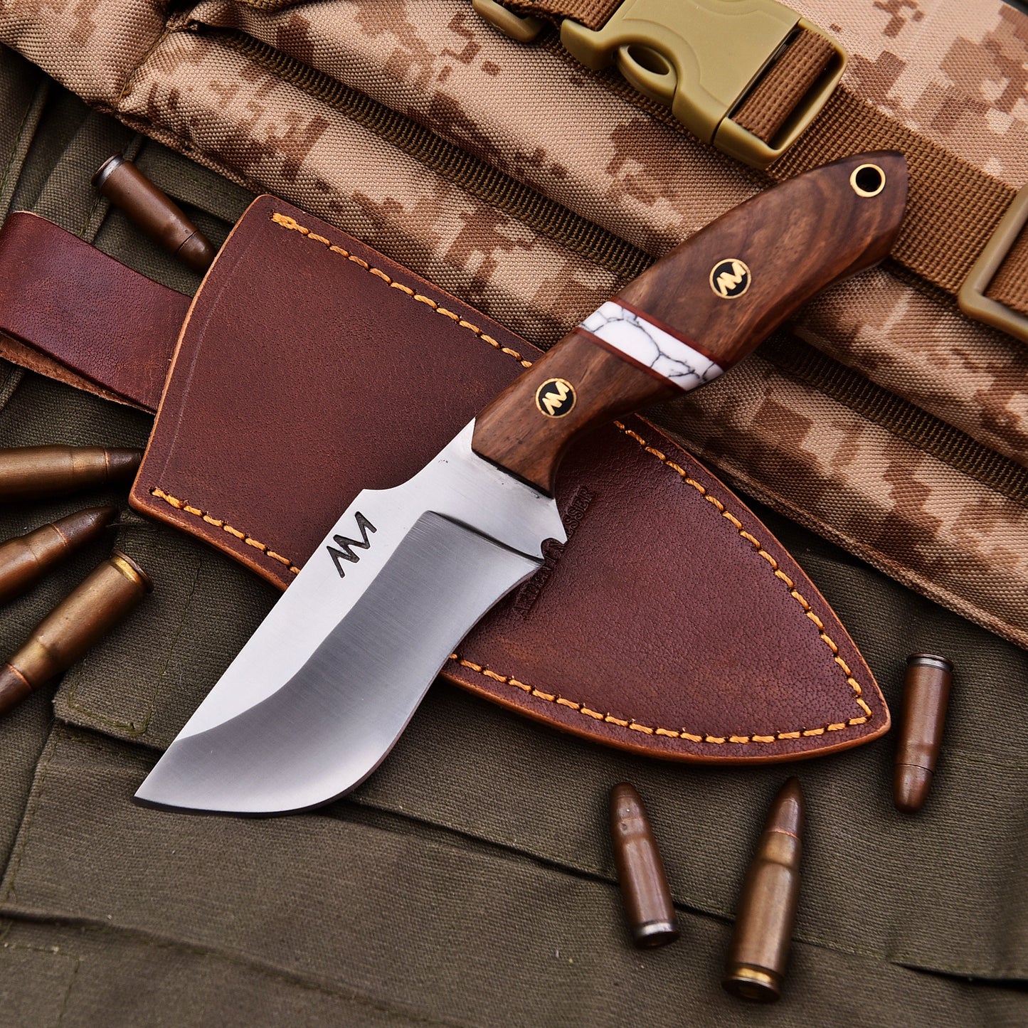 Knife with wooden handle and leather sheath on camouflage fabric with bullets