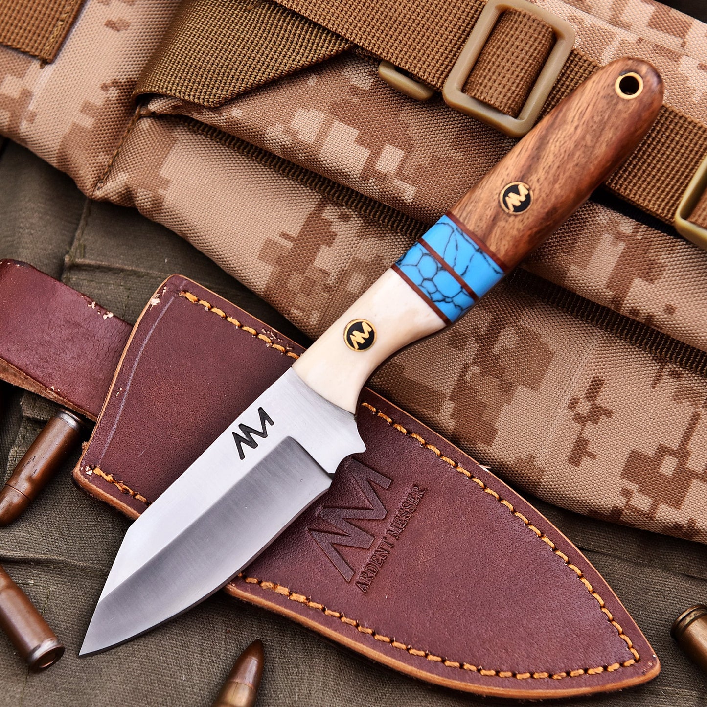 Knife with wooden handle and leather sheath on camouflage fabric
