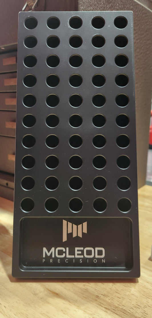 Black makeup palette with 'Mcleod' branding on a wooden surface