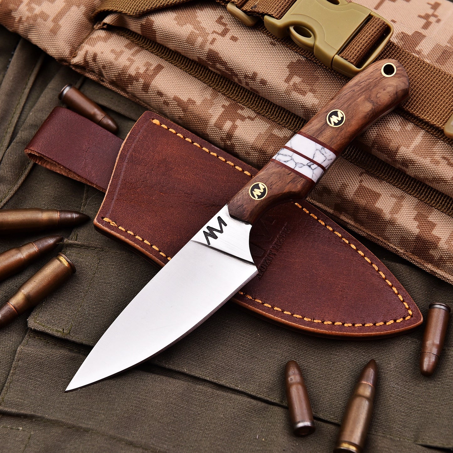 Knife with wooden handle and leather sheath on a camouflage background with bullets.