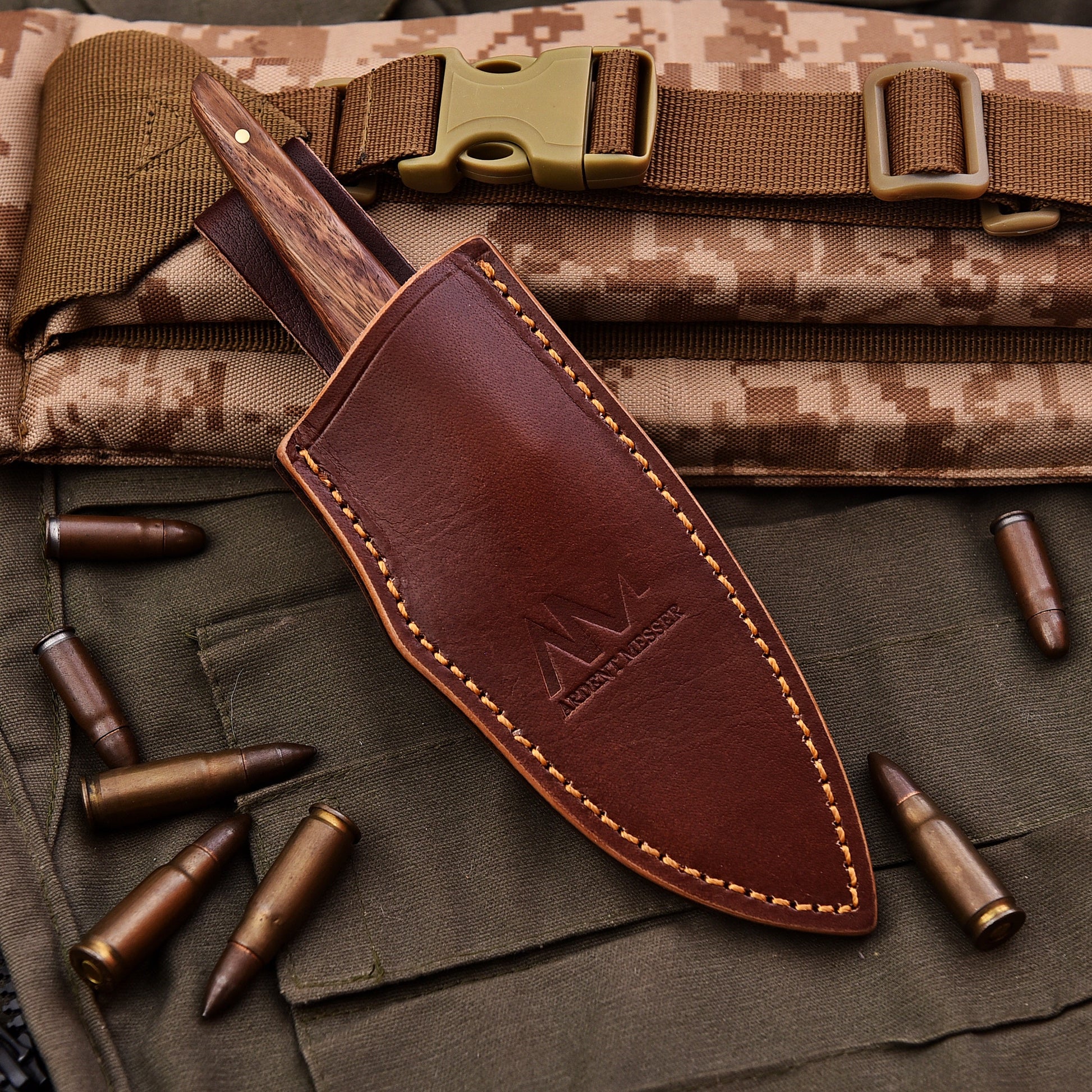 Brown leather knife sheath with a logo on a camouflage background with bullets