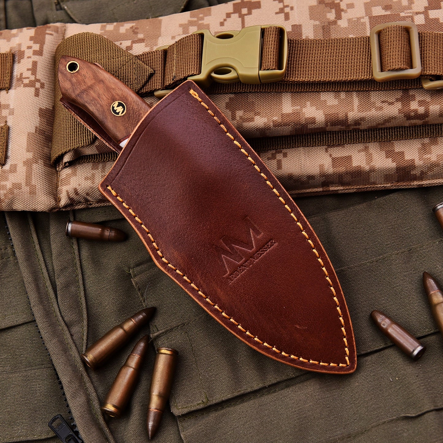 Brown leather sheath with gold stitching on a camouflage background with bullets and tactical gear.