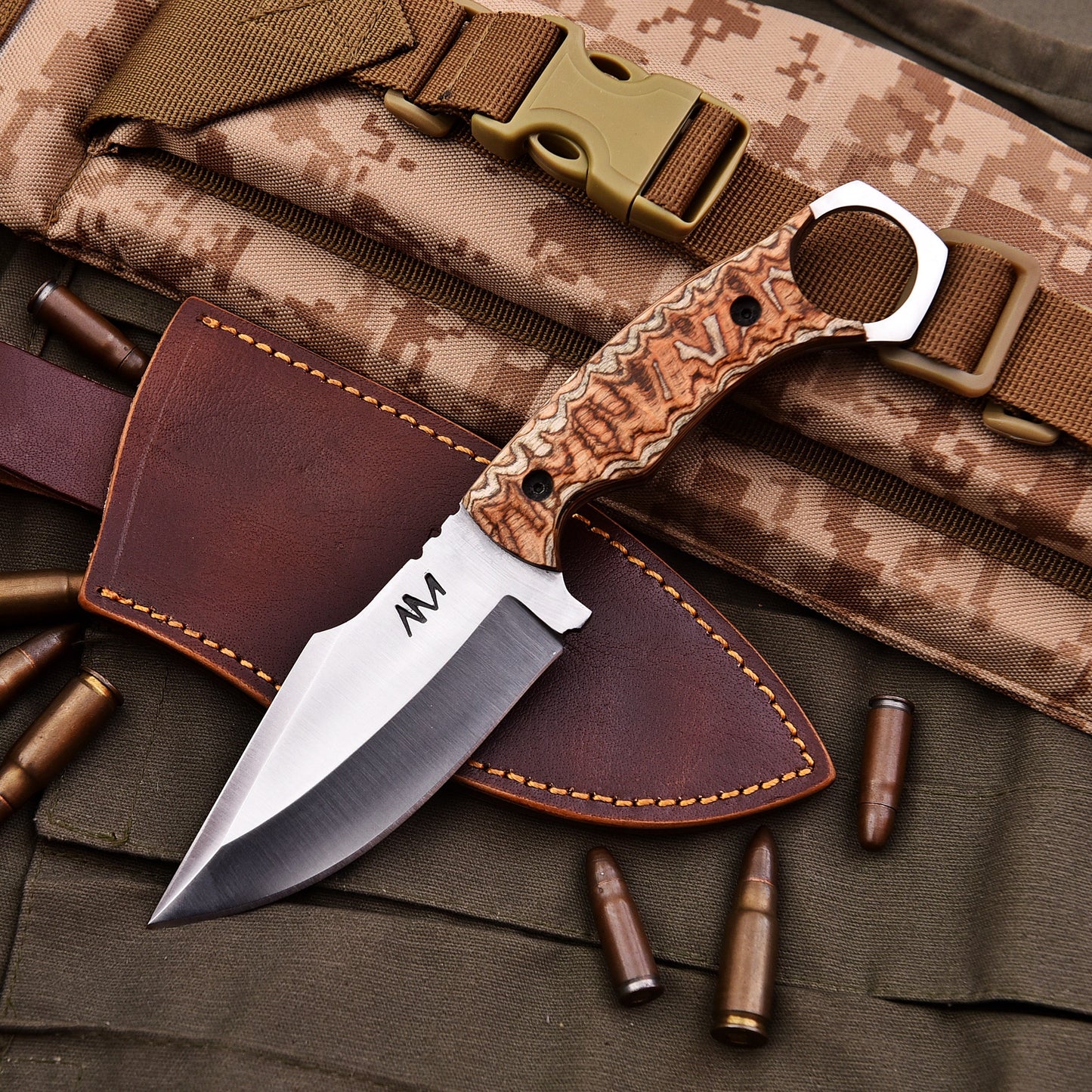 Decorative knife with leather sheath on camouflage background
