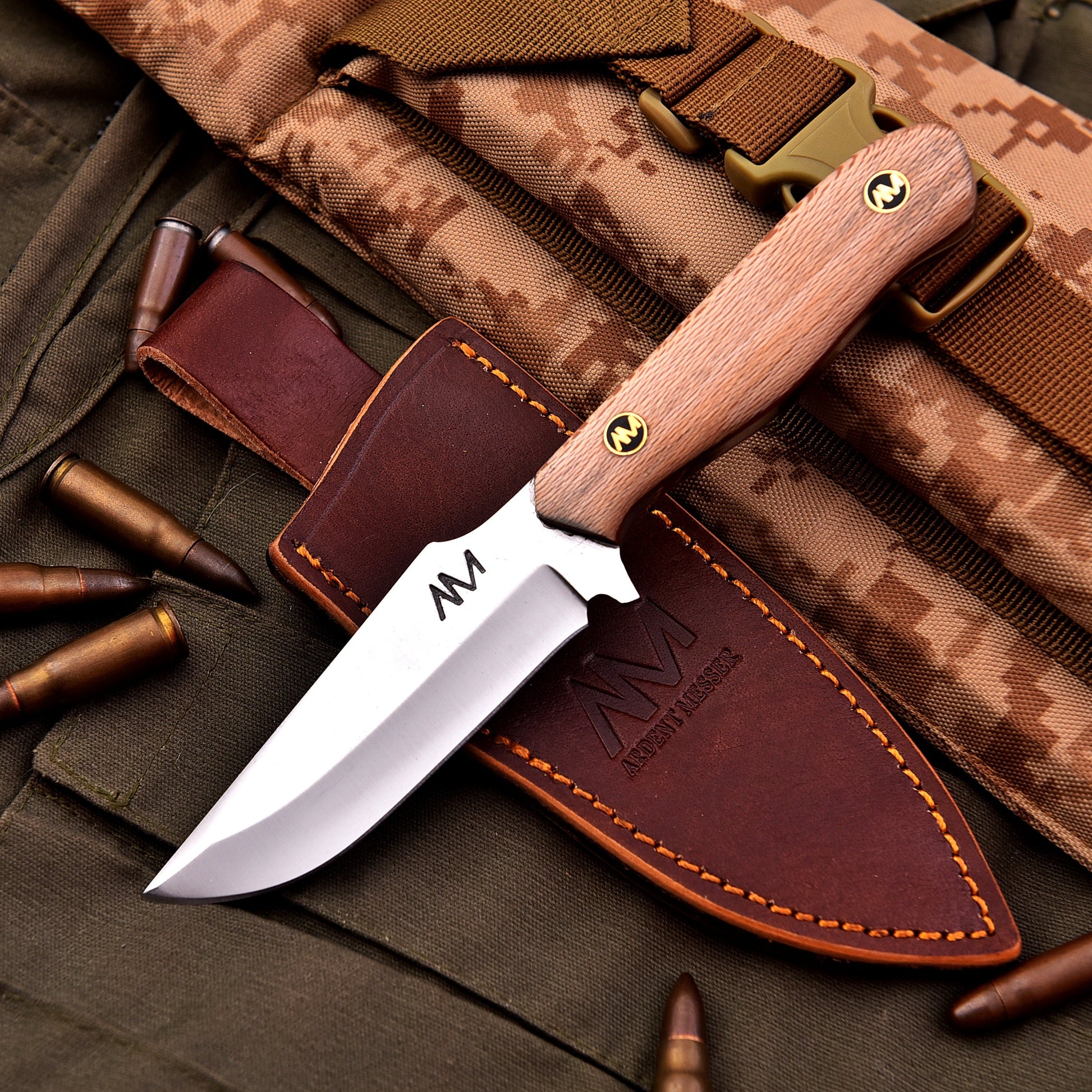 Knife with wooden handle and leather sheath on camouflage fabric with bullets