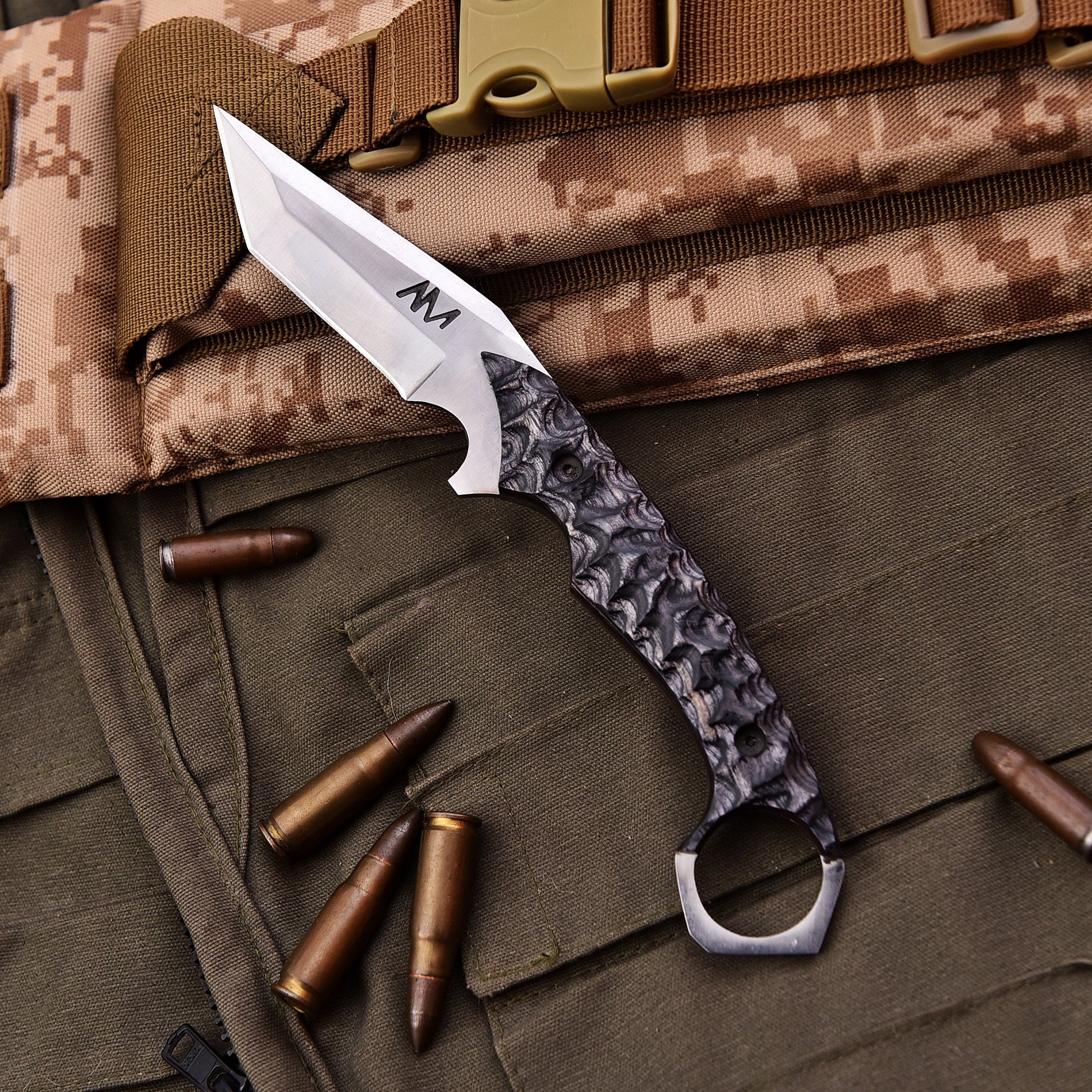 Tactical knife with camouflage background and bullets