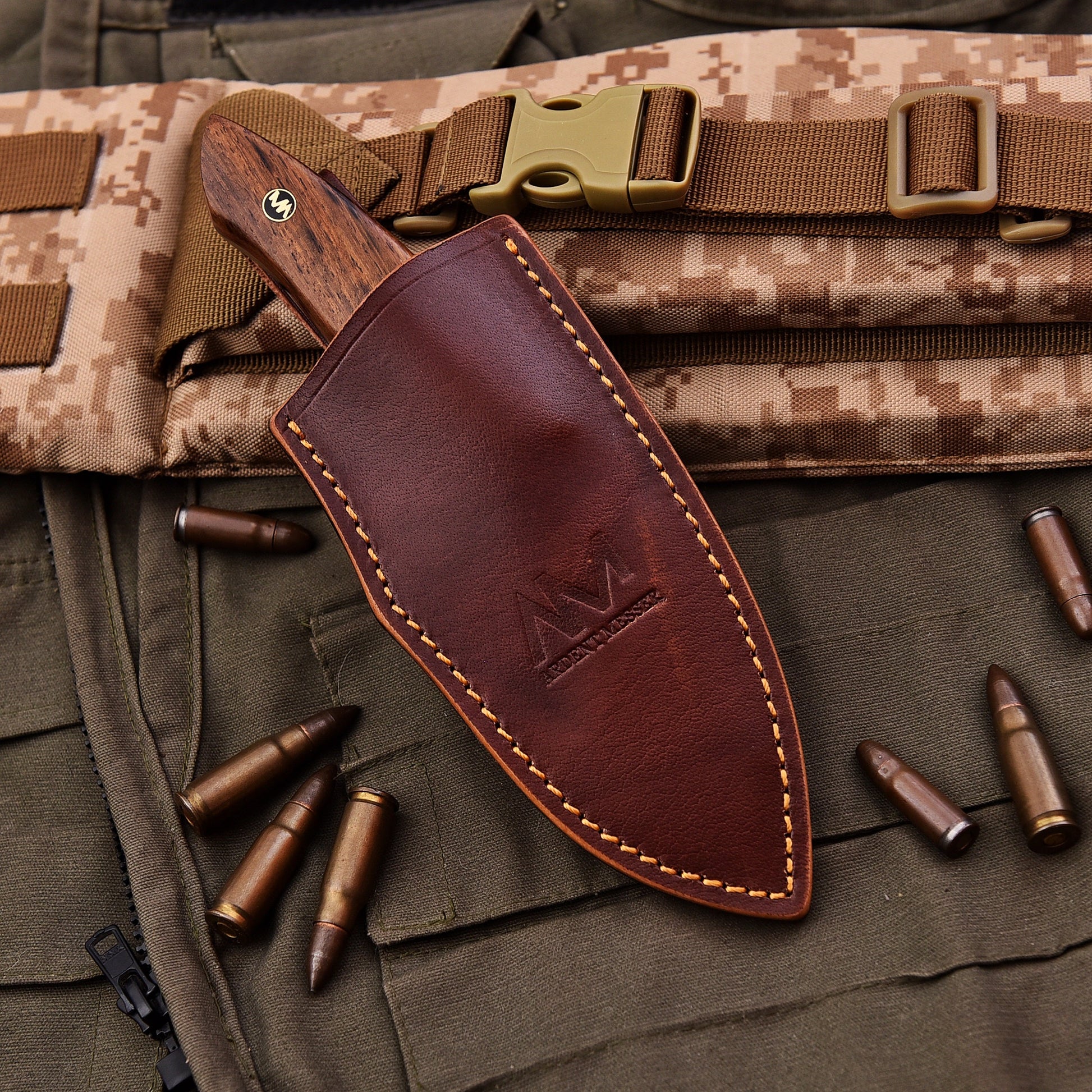 Brown leather knife sheath on a camouflage background with bullets