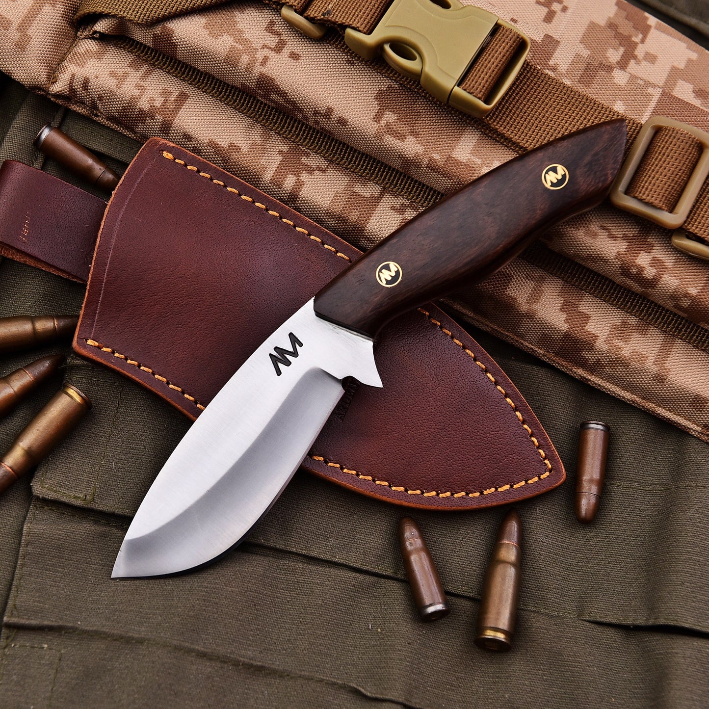Knife with leather sheath on camouflage fabric with bullets