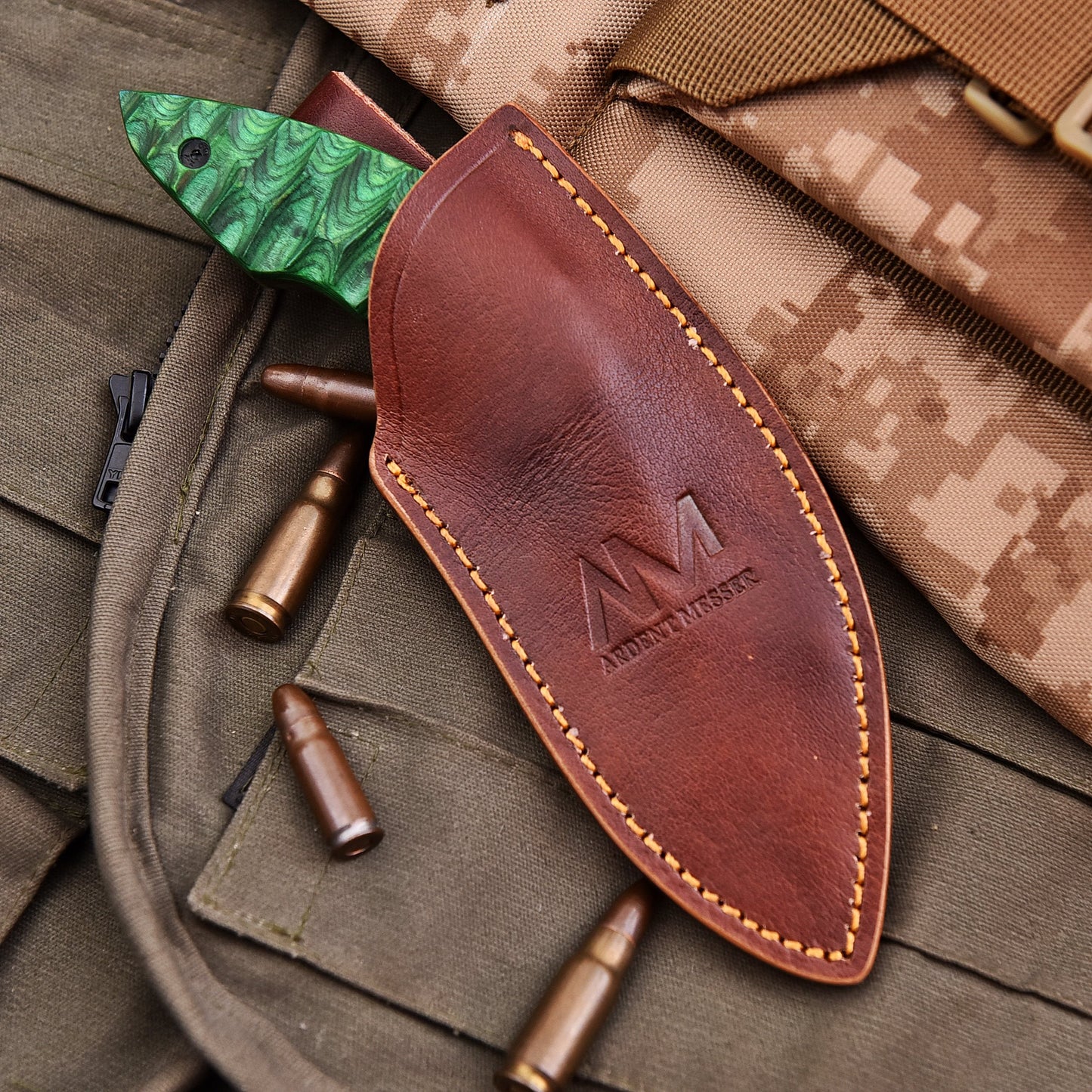 Brown leather knife sheath with green blade on camouflage fabric