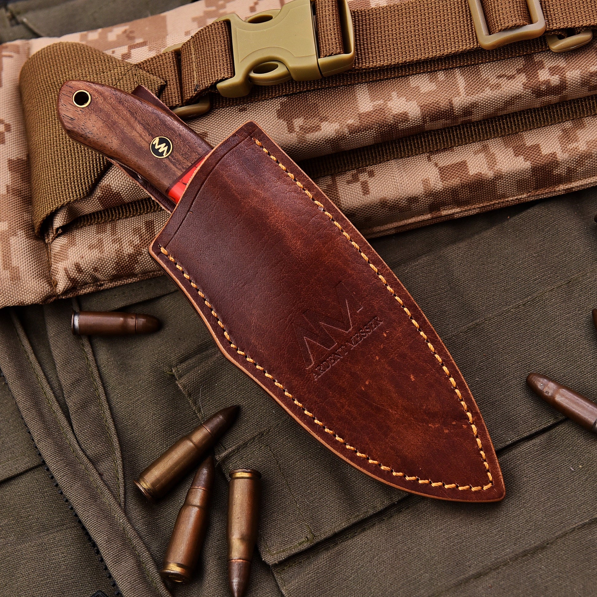 Brown leather knife sheath on a camouflage background with bullets