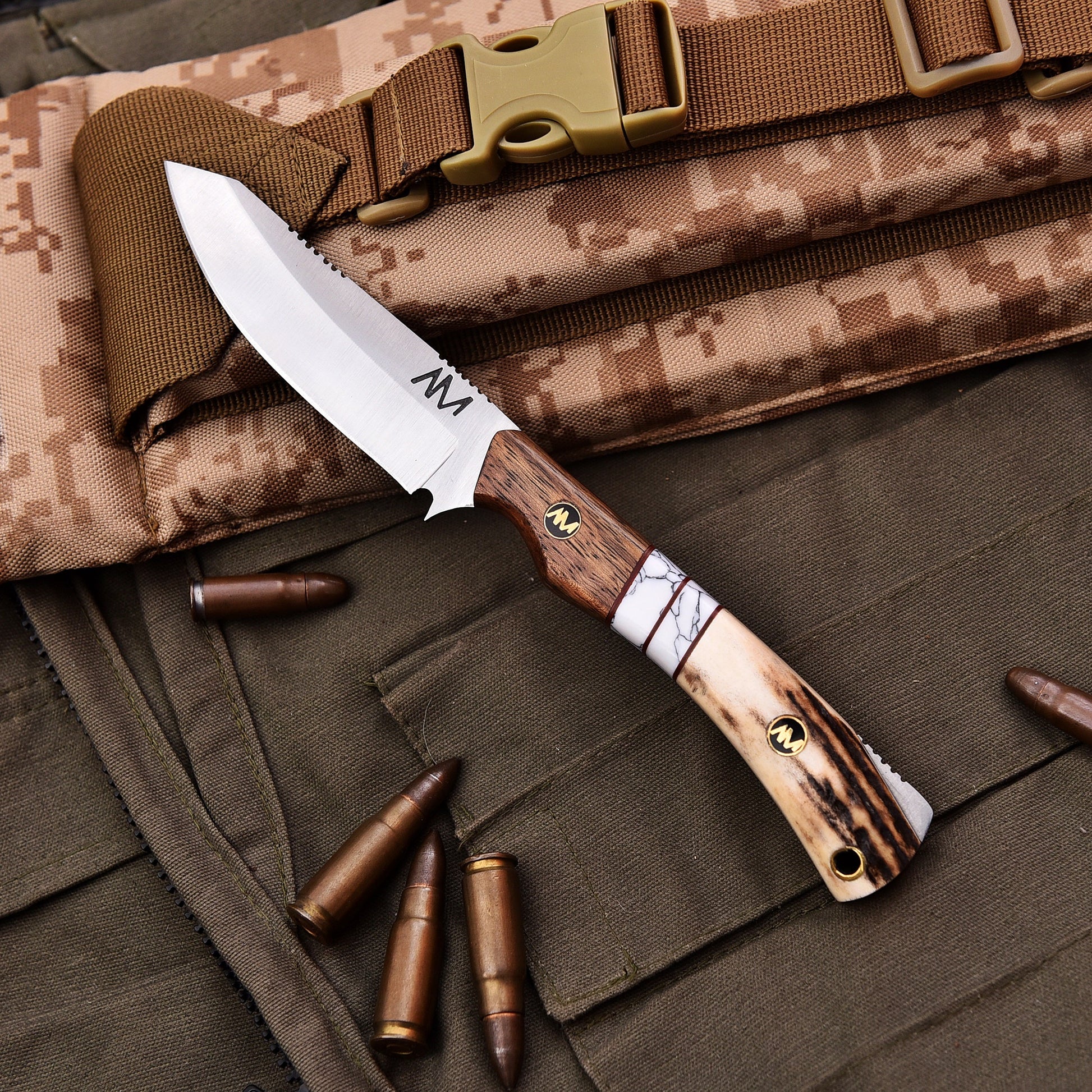 Knife with wooden handle and metal blade on camouflage fabric with bullets