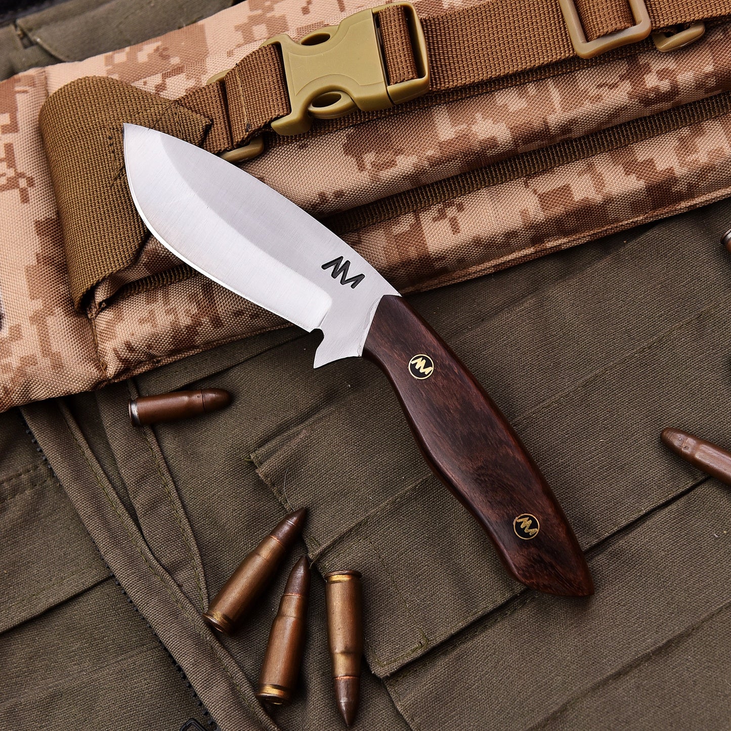 Knife with wooden handle on camouflage fabric with bullets